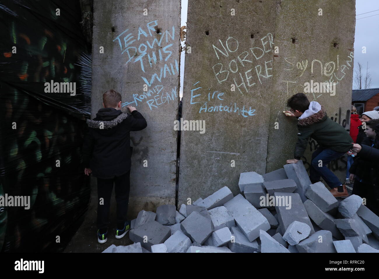 Kinder schreiben Botschaften an Betonblöcke, die vorübergehend wurden als Teil einer anti-Brexit Kundgebung an der irischen Grenze in der Nähe von Carrickcarnan, Co Louth installiert. Stockfoto