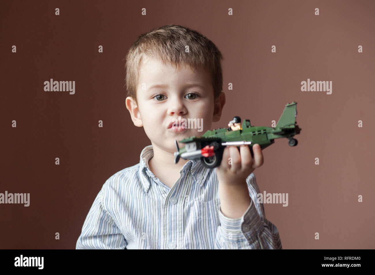 Süßer kleiner Junge spielt mit einem Spielzeug Flugzeug. Militärische Flugzeuge  LEGO Stockfotografie - Alamy