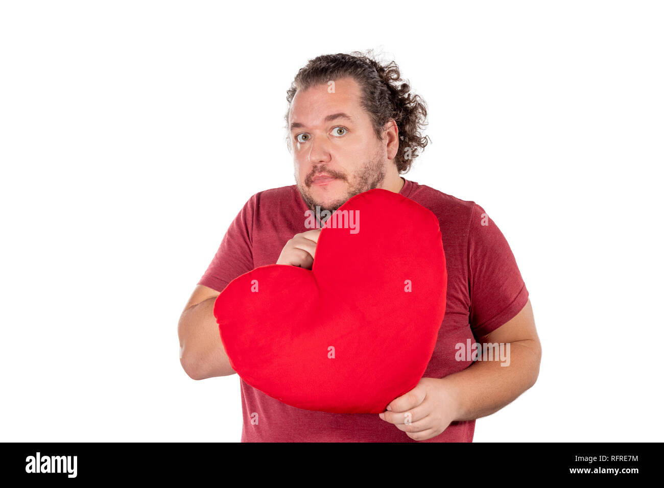 Ein studio geschossen von einem fetten Mann hält eine rote herzförmige Kissen isoliert Stockfoto