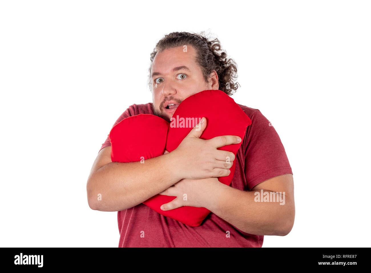 Ein studio geschossen von einem fetten Mann hält eine rote herzförmige Kissen isoliert Stockfoto