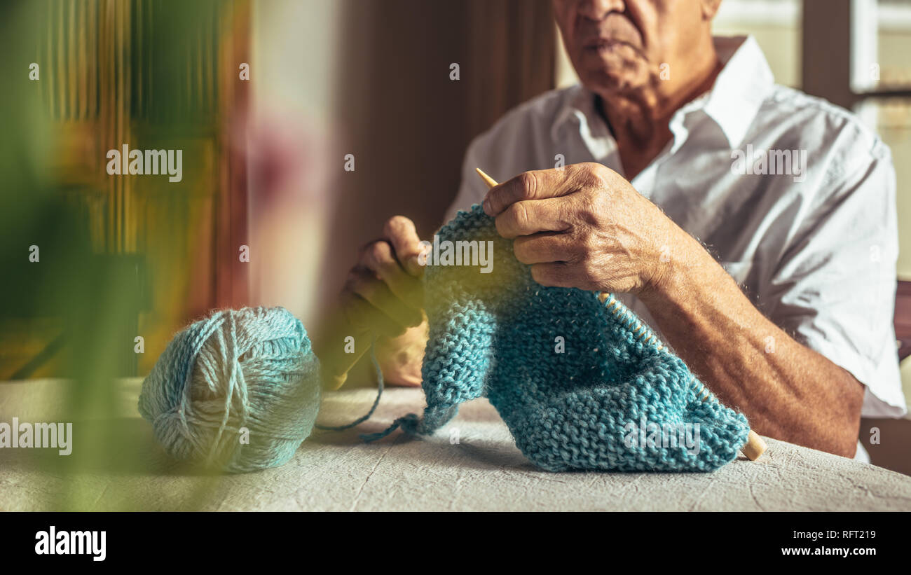 Der alte Mann die Hände stricken mit Nadeln und Wolle Garn. Pensionierter  mann Stricken zu Hause Stockfotografie - Alamy