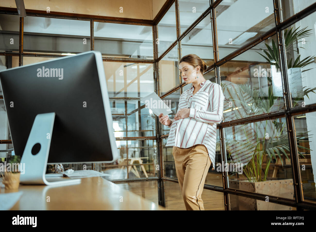 Schwangere Frau im modernen Büro der Corporation arbeiten Stockfoto