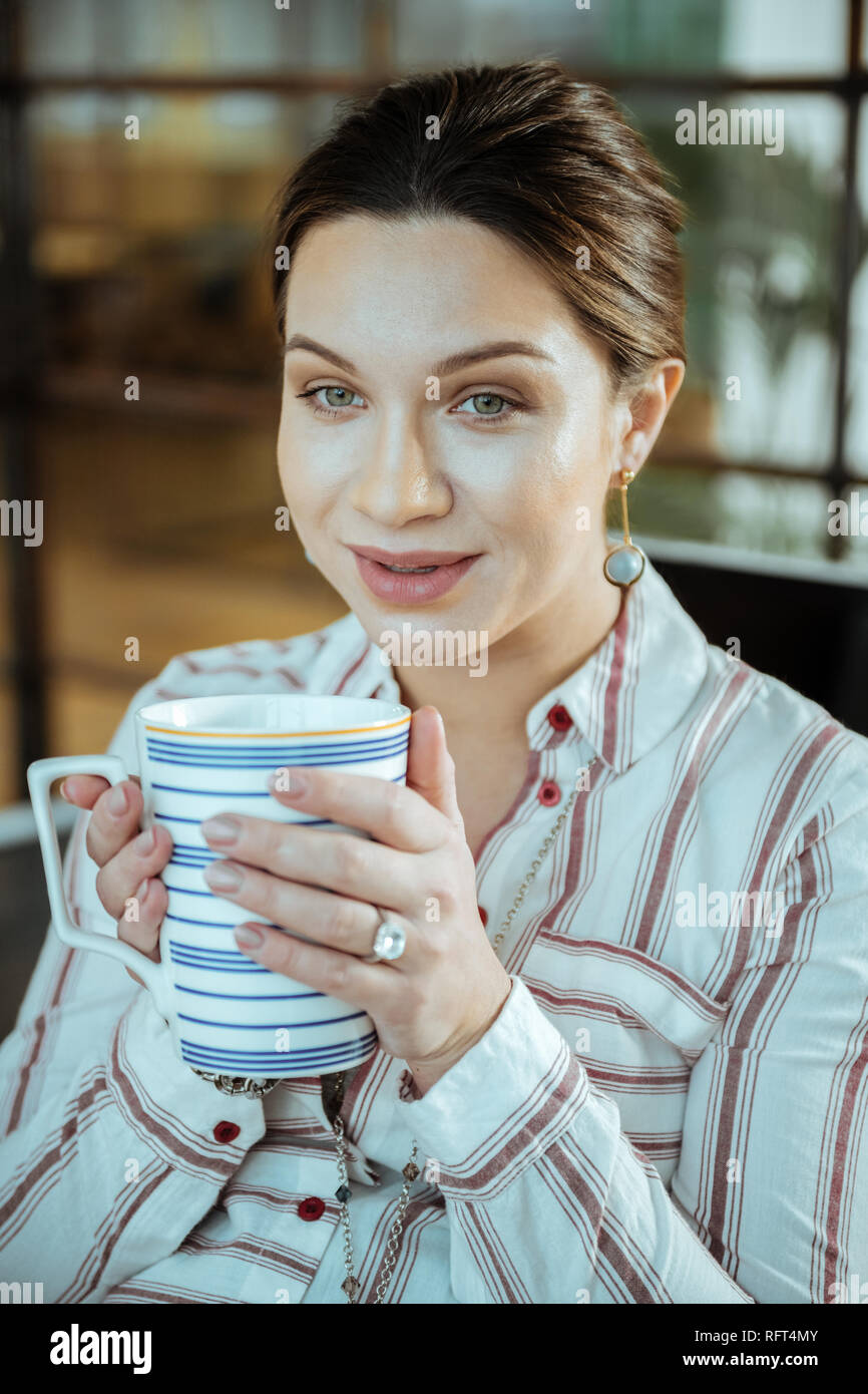 In der Nähe von schönen dunkelhaarige Frau mit großen Tasse Tee Stockfoto