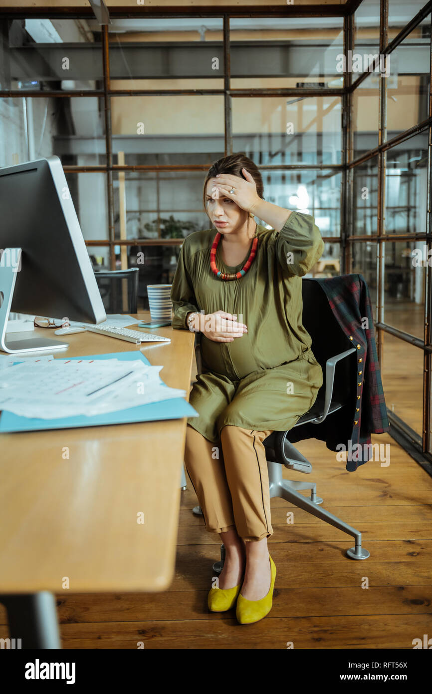 Schwangere stilvolle Geschäftsfrau mit schlechten unerwartete Schmerzen Stockfoto