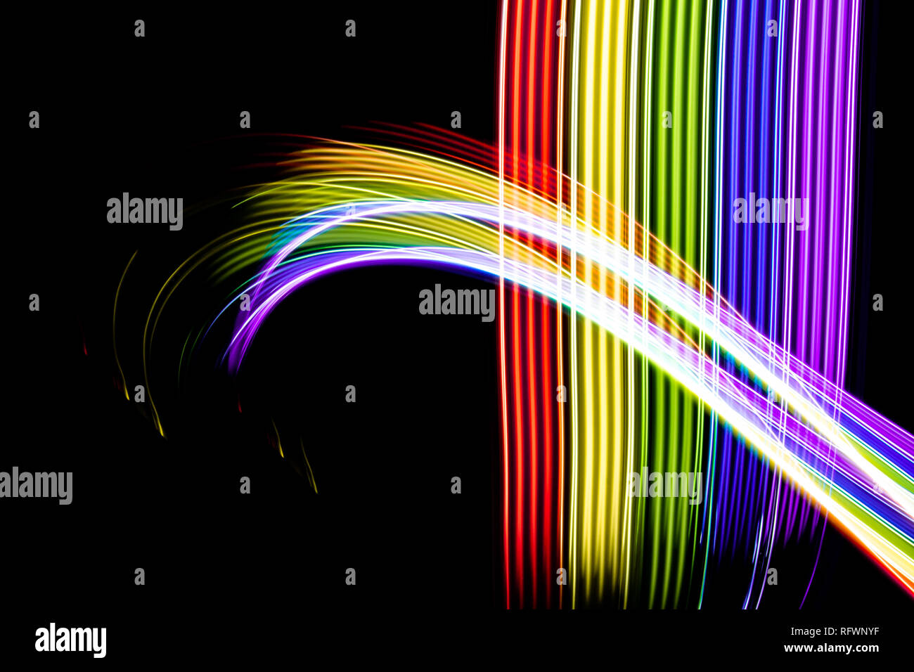 Regenbogen von Licht. Fotografie mit Licht malen. Abstrakte Linien mit den Farben des Regenbogens auf schwarzem Hintergrund. Ressource für Designer. Stockfoto