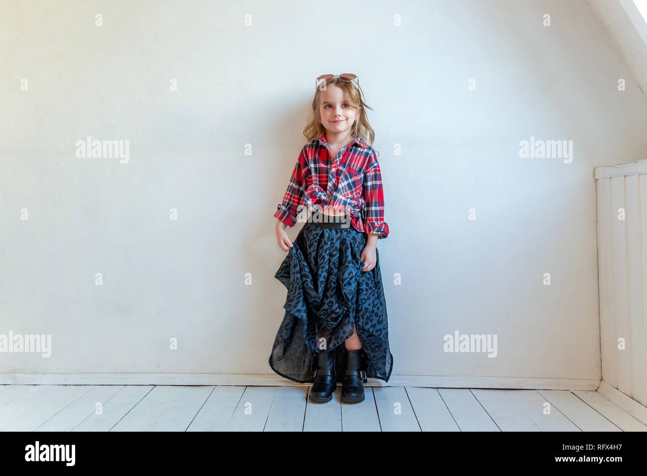 Süße happy adorable Mode junge Mädchen gekleidet wie Hippie hippie gypsy Cowboy in Sonnenbrille gegen weiße Wand Hintergrund im Licht stehenden Stockfoto