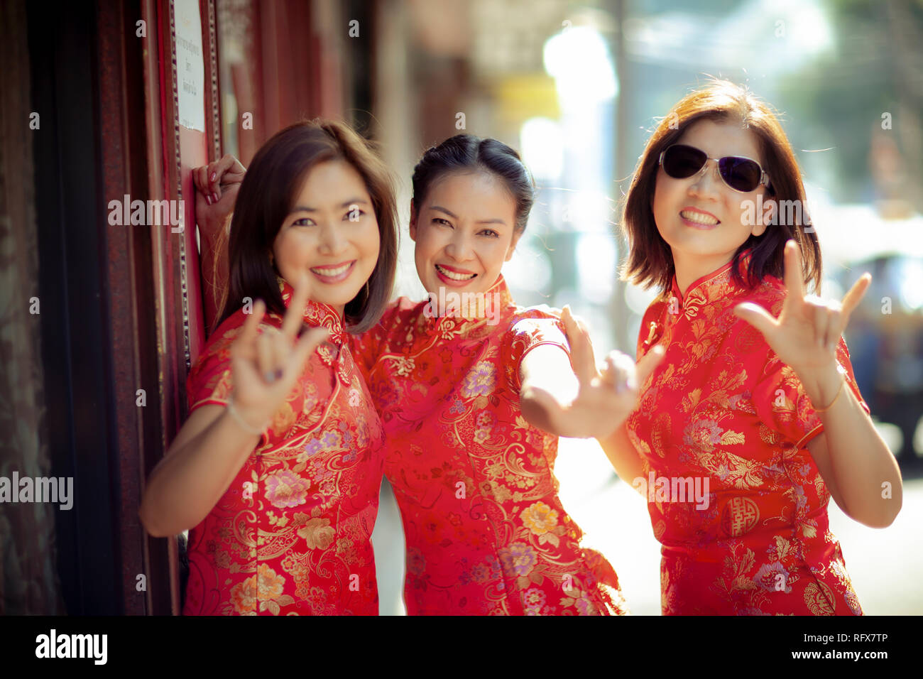 Gruppe von asiatischen Frau in der chinesischen Tradition Kleidung toothy Lächeln glück Emotion und hand Zeichen ich liebe dich Stockfoto