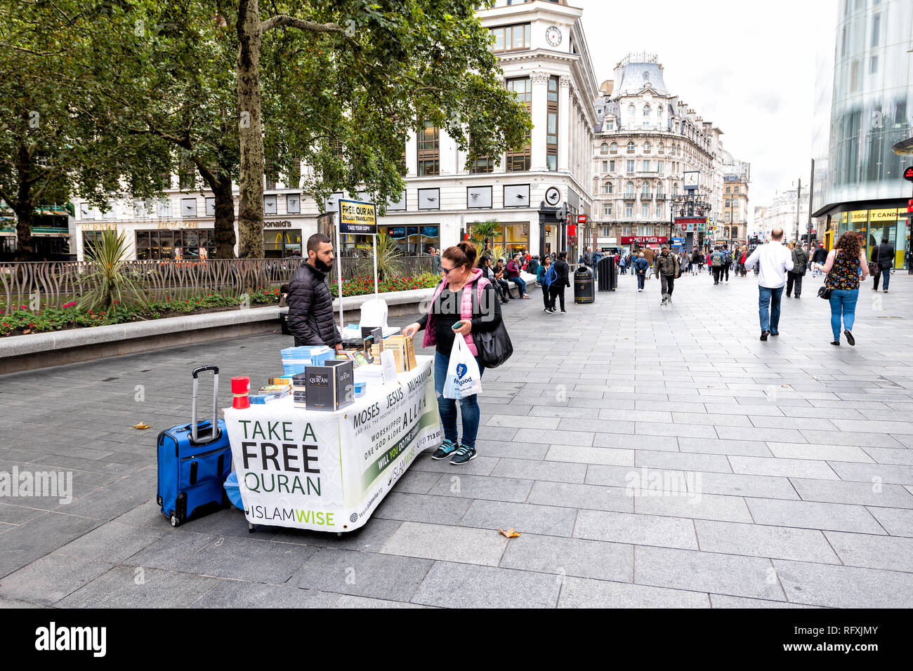 London, Großbritannien - 12 September 2018: Menschen, Frau und Mann durch Freie Quaran Islam Religion stand stand auf dem Bürgersteig Street Shopping in Leicester Square Stockfoto