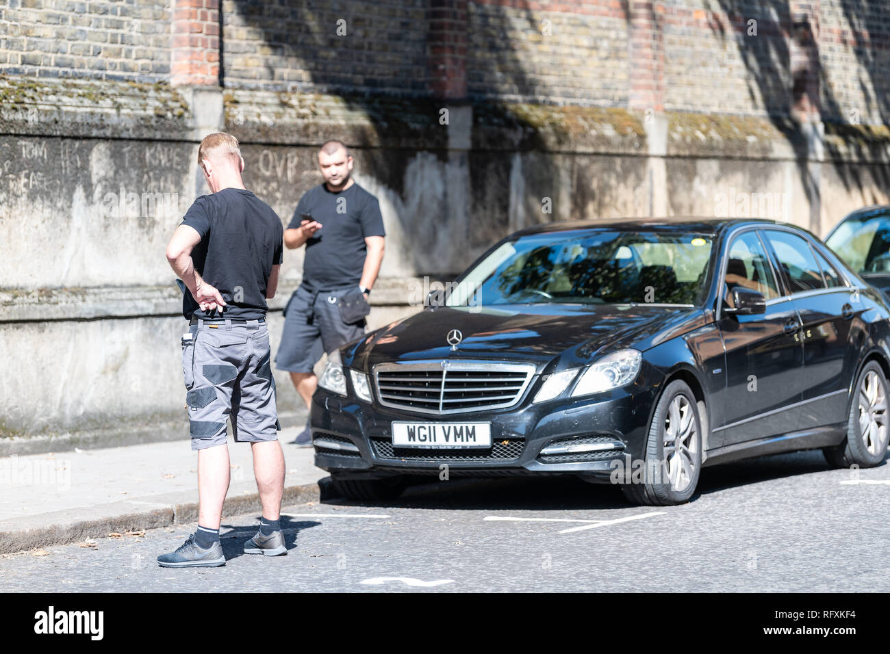 London, Großbritannien - 13 September, 2018: die Straße in Belgravia, ehrliche Männer zwei Sicherheitsleute stehen mit Telefon auf Pflaster von geparkten Auto Stockfoto