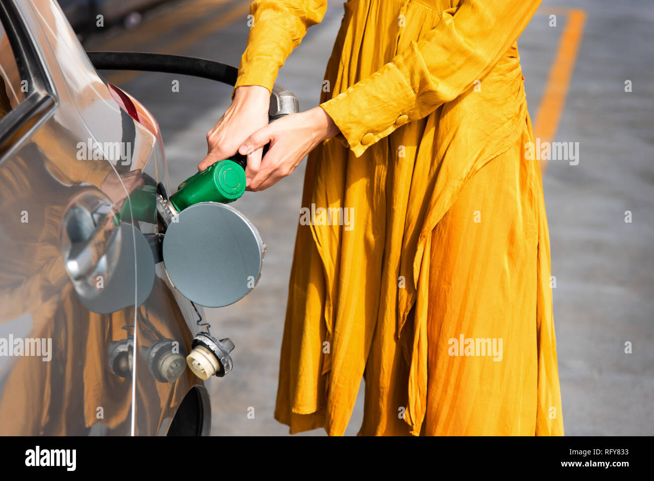 Frau Hinzufügen von Benzin an der Tankstelle allein Stockfoto