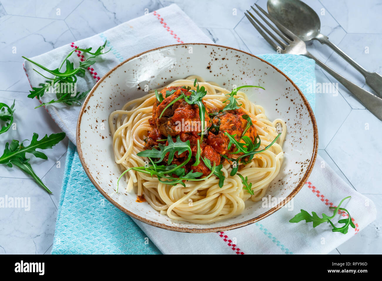 Spaghetti mit Thunfisch Kugeln in pikanter Tomatensauce und Rakete Stockfoto