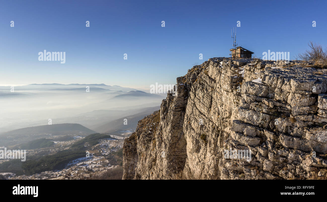 Sonnige felsige Gipfel mit Ruine an der Oberseite und sanften Landschaft und die Berge in der Ferne Schichten durch Nebel Stockfoto