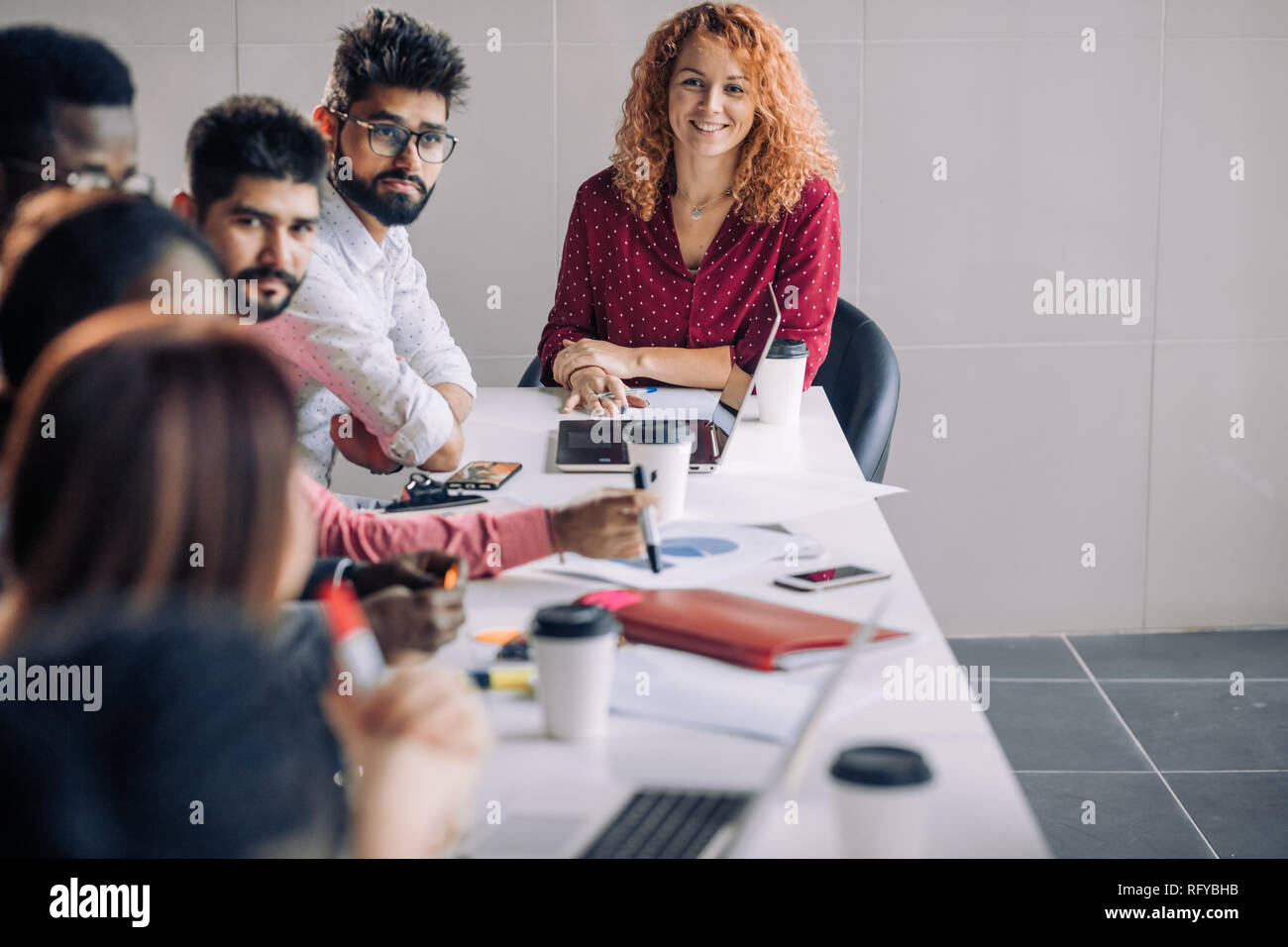 Gemischte Rasse Menschen hören Präsentation in Zeile am Konferenztisch Stockfoto