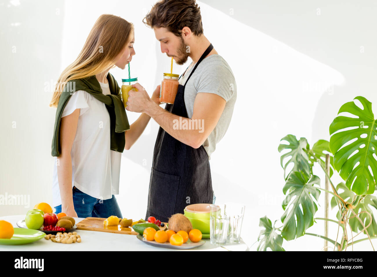 Zwei angenehme Menschen trinken Saft aus Strohhalmen Stockfoto