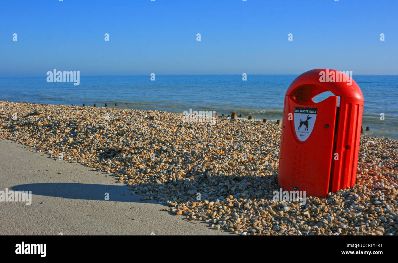 Red Dog Papierkorb am Strand von felpham in der Nähe von Chichester, West Sussex, Großbritannien Stockfoto