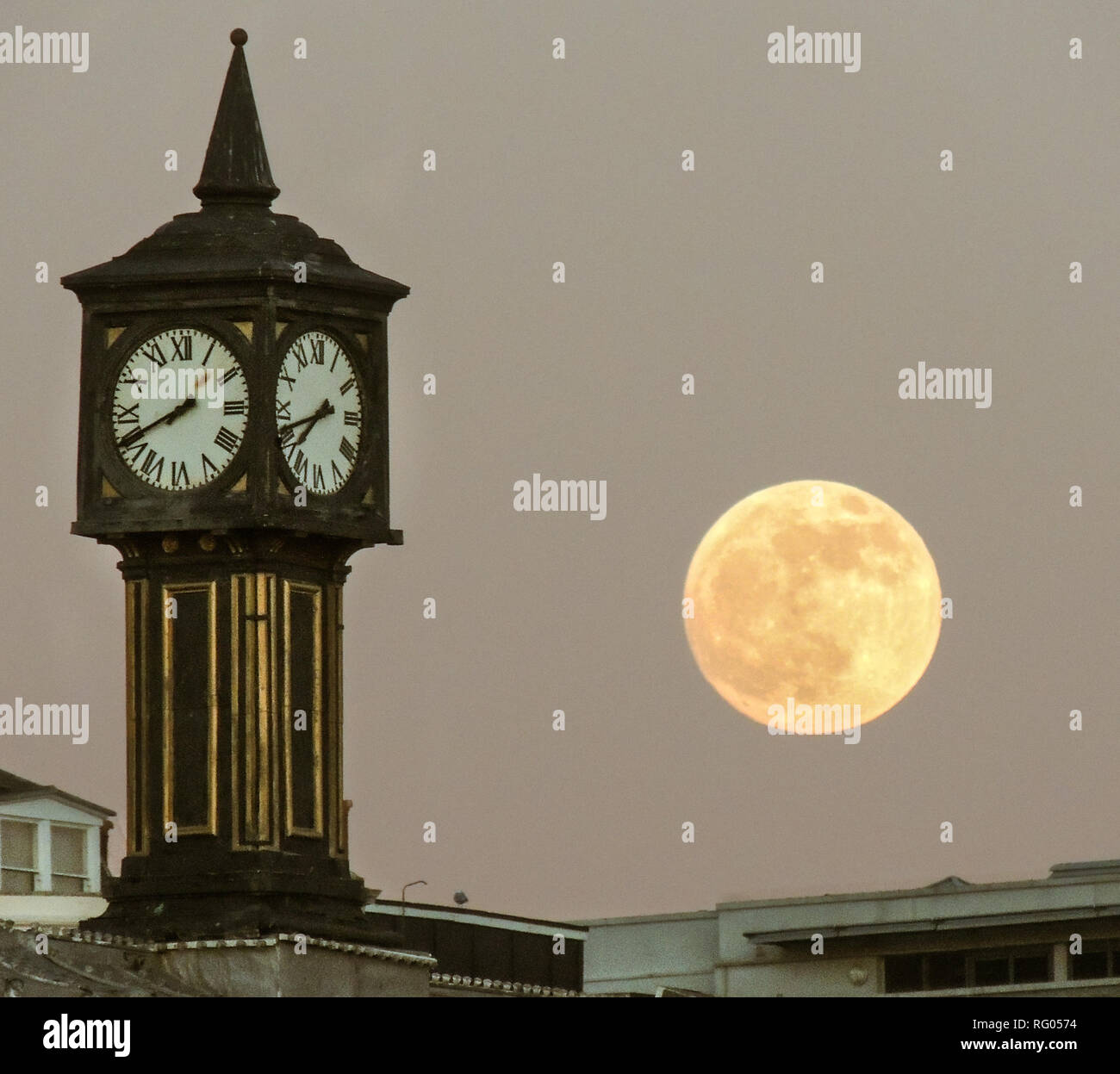 Vollmond - Mondaufgang am Palace Pier Clock Tower, Brighton - direkt am Meer Stockfoto