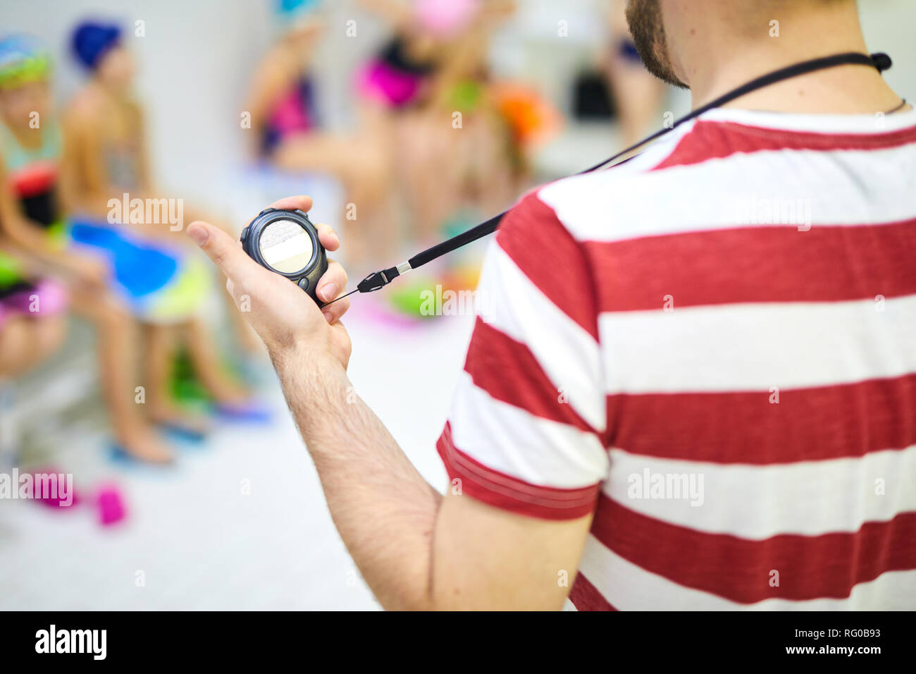 Schwimmen Trainer an seine Stoppuhr suchen Stockfoto