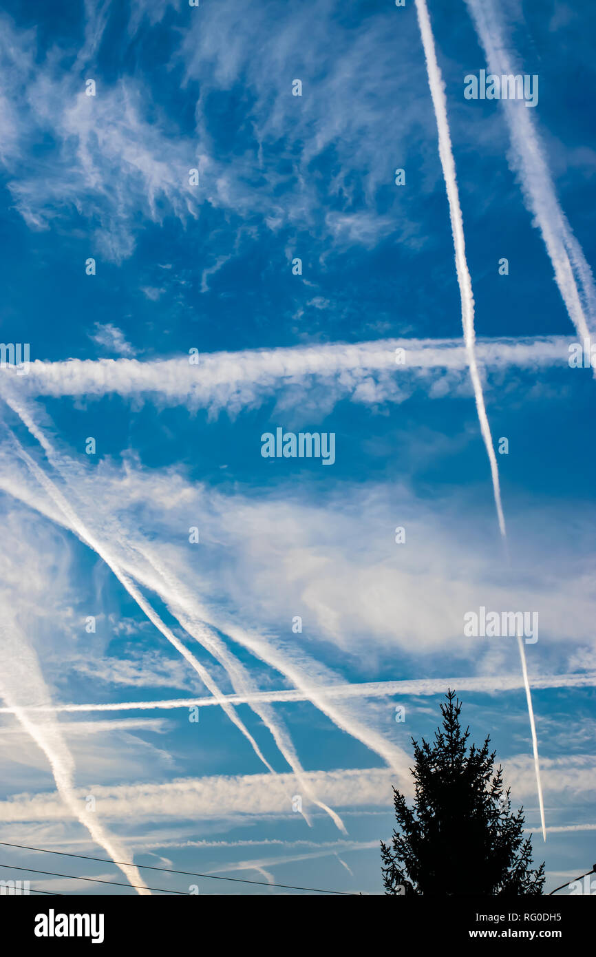 Blick auf den blauen Himmel über der Stadt, von den Spuren der Flugreisen. Stockfoto