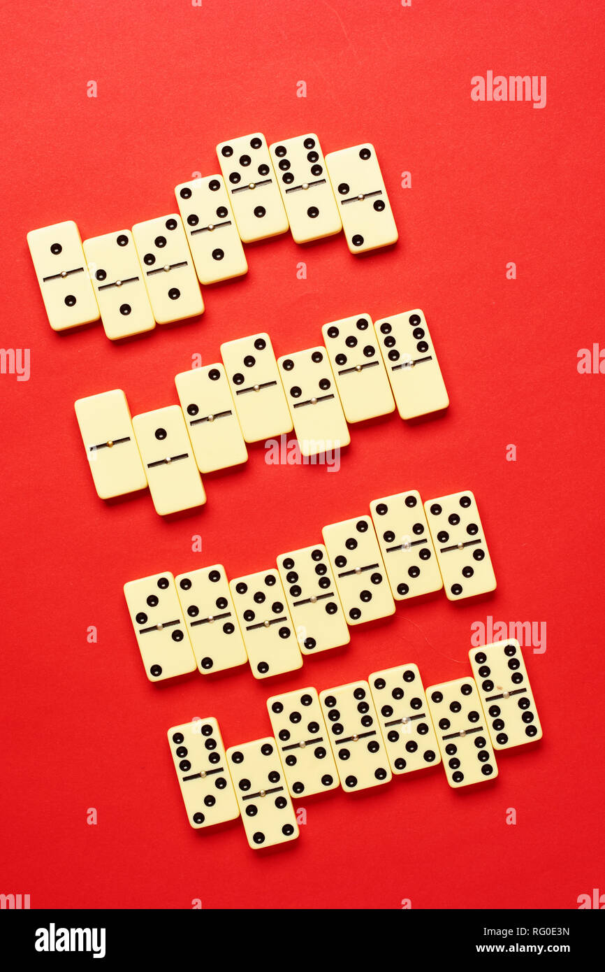 Flach Konzept. Gesellschaftsspiele Publikationen. Domino Stücke auf dem roten Hintergrund mit kopieren. Stockfoto