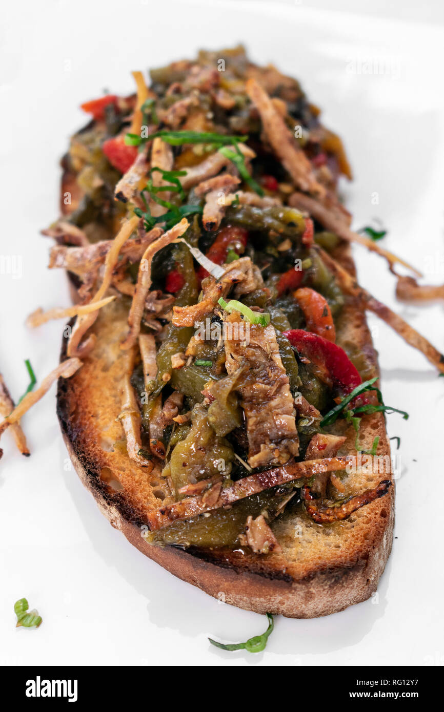 Würzigen getrockneten Tintenfisch und gebratenem Gemüse sandwich Tapas in Portugal getoastet Stockfoto