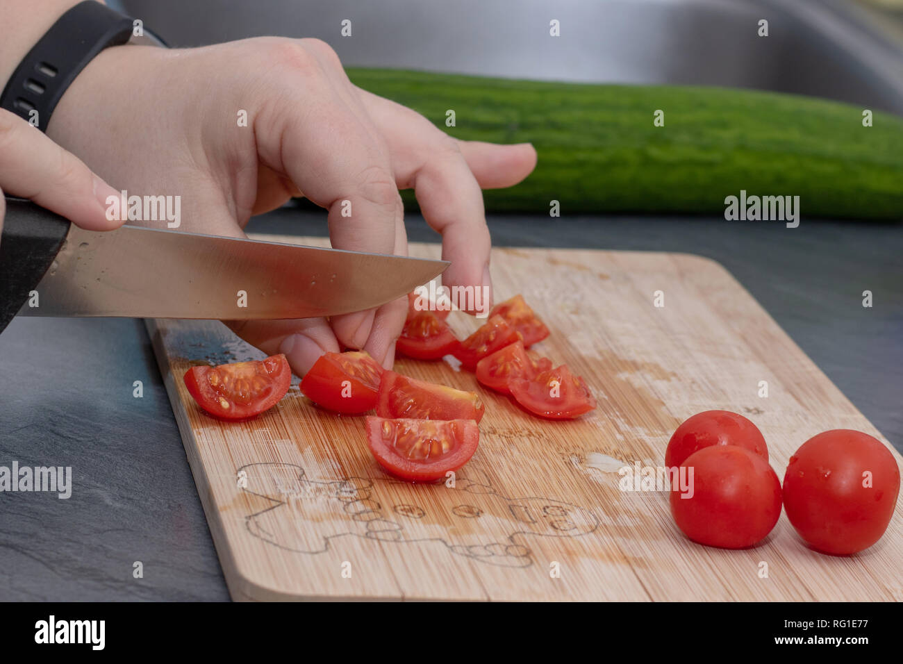 Frauenhand Tomate hinter frisches Gemüse schneiden. Stockfoto