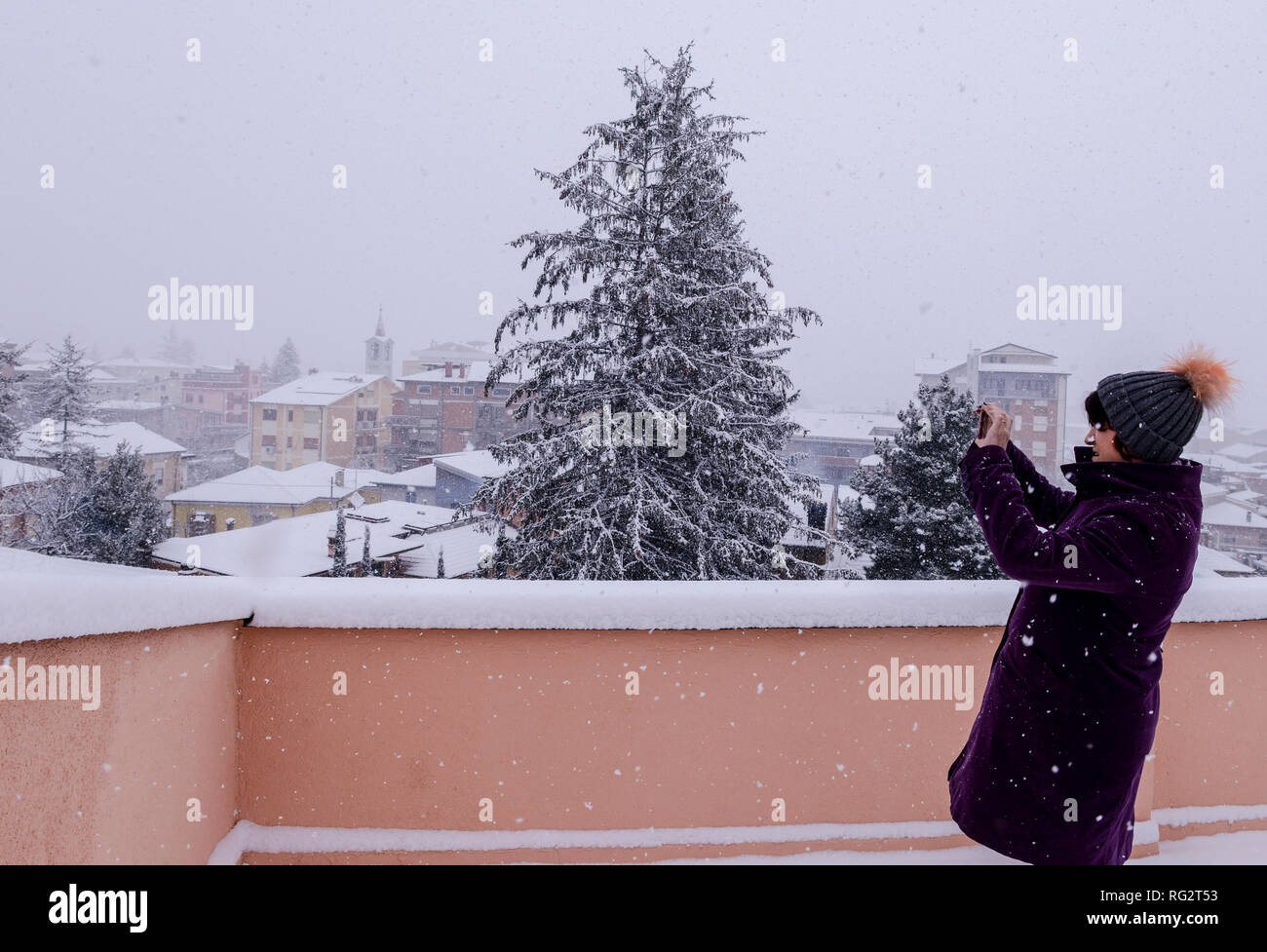 Frau im Freien, auf dem Balkon, machen Fotos der schneebedeckten malerische Aussicht, bei Schneesturm, Avezzano, Abruzzen, Italien, Europa Stockfoto