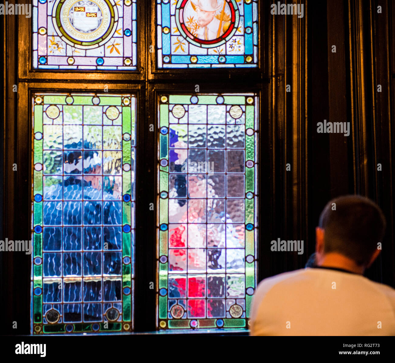 Person, die durch die Buntglasfenster, verzerrten Sicht der Passanten durch das Fenster gesehen, Hull, East Yorkshire, England, Großbritannien Stockfoto