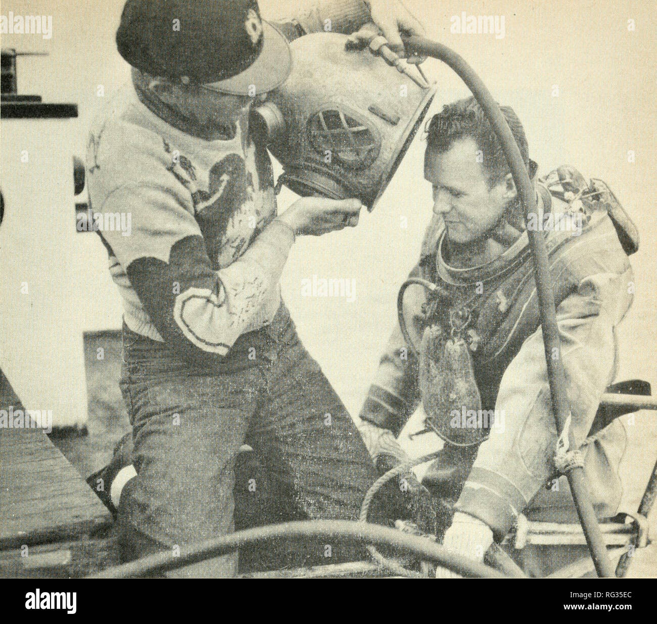 . Kalifornien Fisch und Wild. Fischerei - Kalifornien; Spiel und Spiel - Vögel - Kalifornien; Fische - Kalifornien; Tier Bevölkerungsgruppen; Pêches; Gibier; Poissons. Platzieren der Helm auf der Taucher. Beachten Sie die Gewichte auf der Brust des Taucher und zurück. Die großen schwarzen Schlauch trägt sowohl die Luftzufuhr des Tauchers und sein Telefon. Taucher wird in der Kommunikation mit der Oberfläche zu allen Zeiten über die zwei-Wege-Telefon. Foto von Gen Tupper, Palo Alto. Eine Umfrage, die kürzlich von der Abteilung der Fische und des Spiels durchgeführt hat einige interessante Informationen, die wirft etwas Licht auf dieses Problem aufgedeckt. Brie Stockfoto