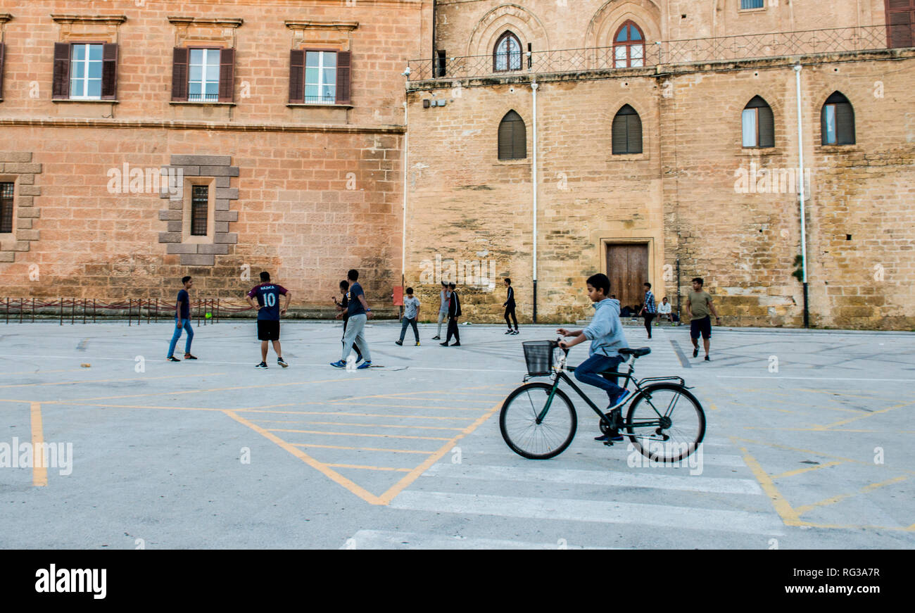 Spielende Kinder im Straßenverkehr, Mädchen reiten Fahrrad im Vordergrund, Palermo, Sizilien, Italien, Europa Stockfoto