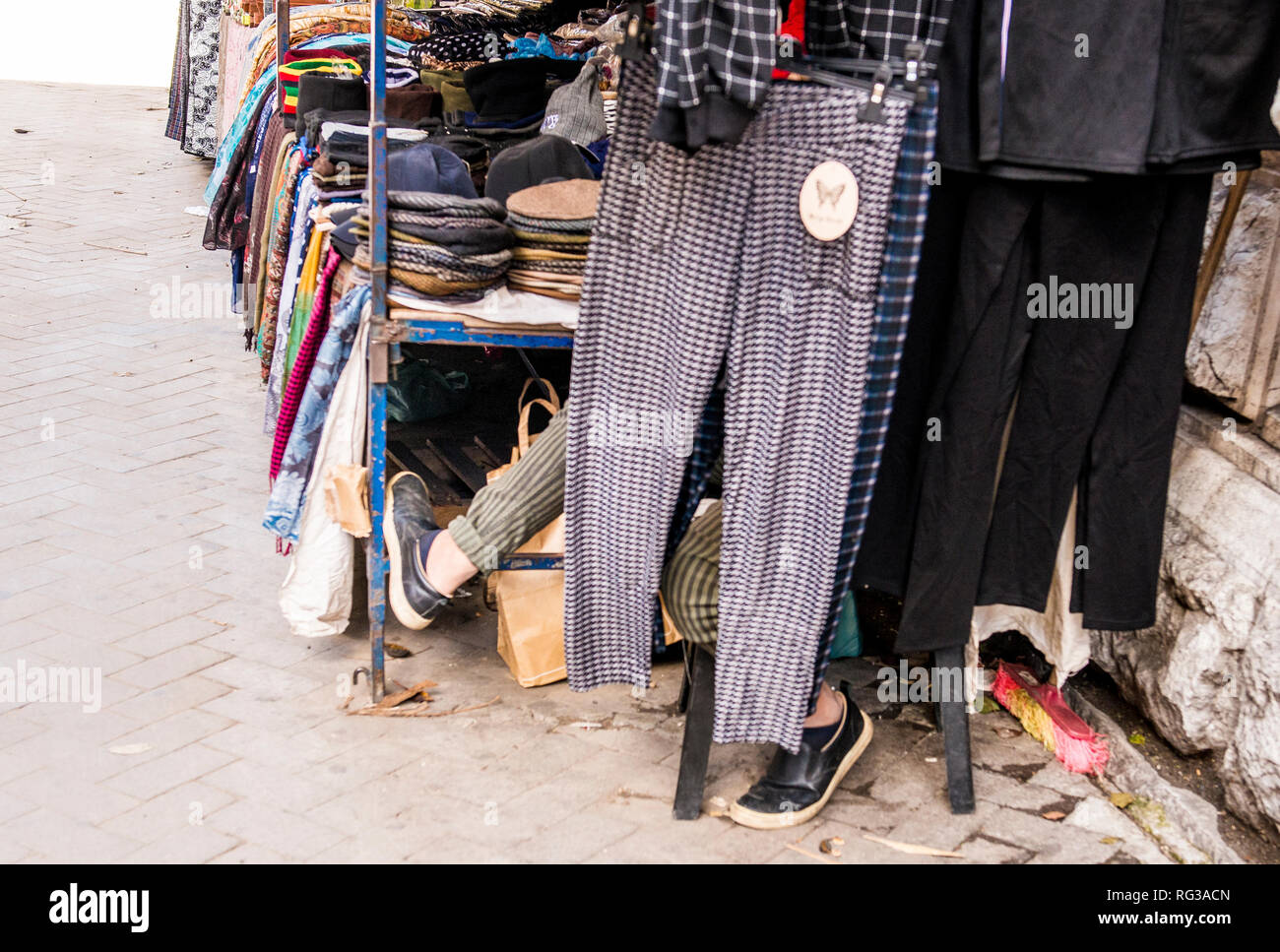 Mann neben Markt sitzen, Füße stoßen von hinten hängenden Hosen, Palermo, Sizilien, Italien, Europa Stockfoto