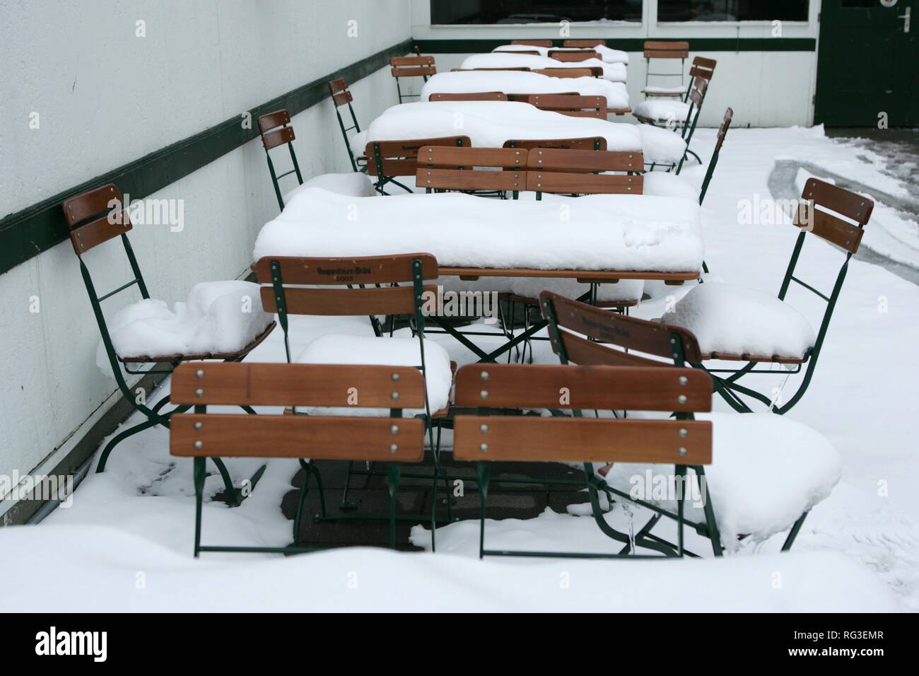 DEU, Deutschland, München: Schnee bedeckt Tische und Stühle im Biergarten Restaurant. Stockfoto