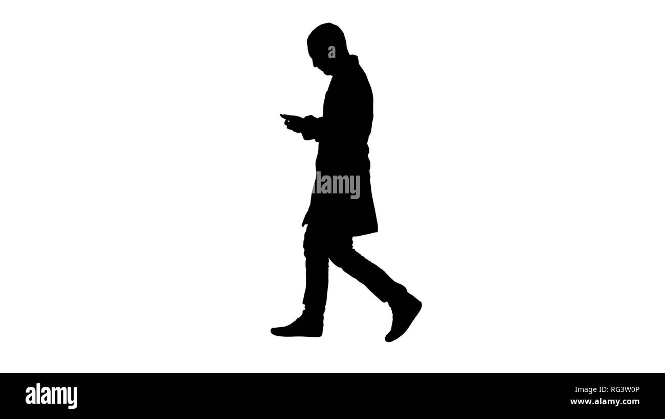 In voller Länge Porträt von der Seite. Silhouette männlicher Arzt gehen und mit Handy. Professionelle Aufnahme in 4K-Auflösung. 004. Sie können es verwenden, um z. B. in Stockfoto