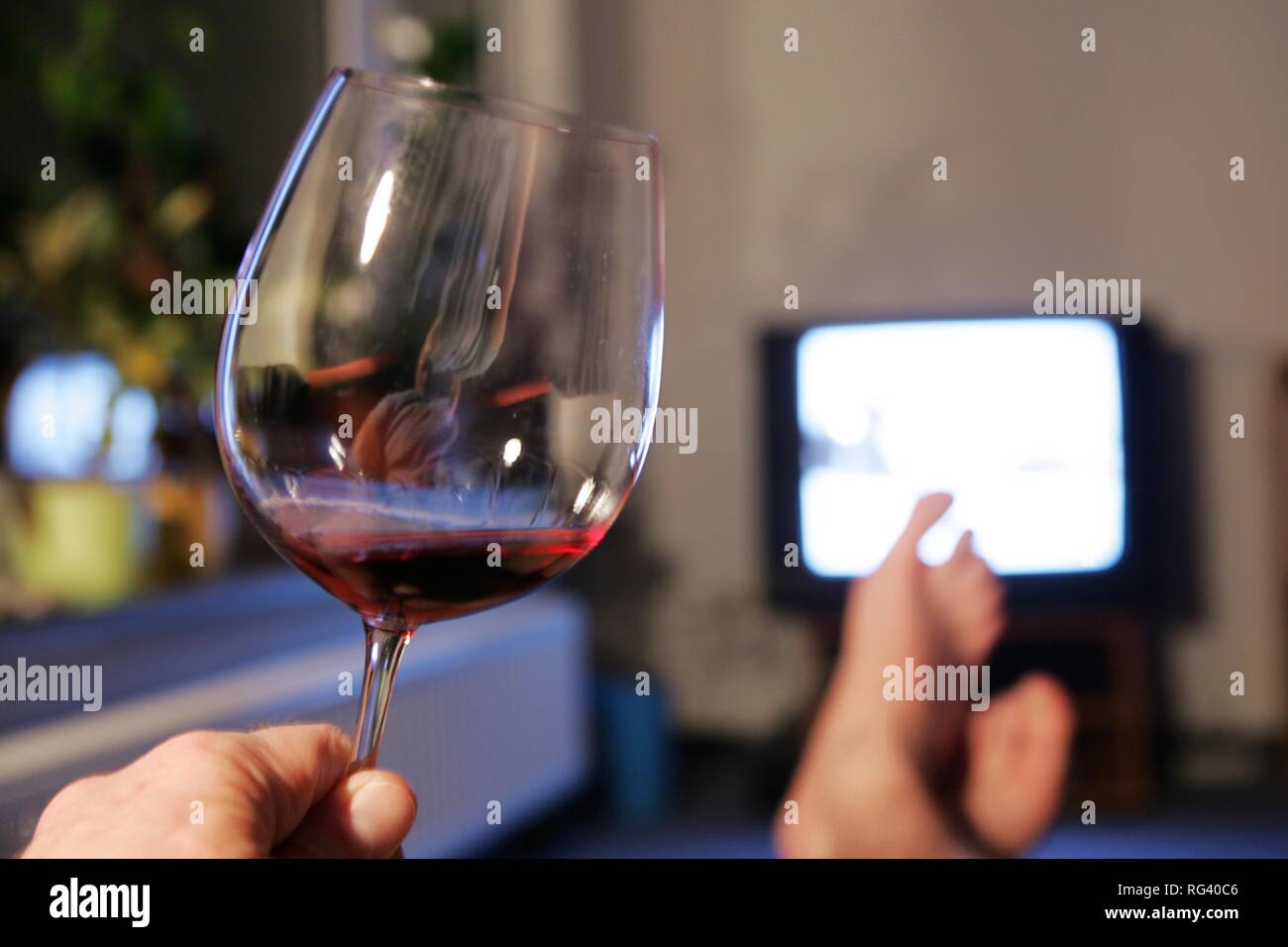 DEU, Deutschland: Mann vor einem TV. Glas Rotwein. Stockfoto