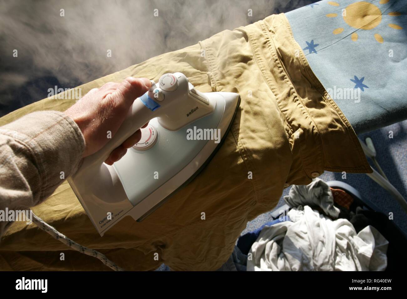 DEU, Deutschland: Bügeln von Wäsche zu Hause. Dampfbügeleisen. Stockfoto
