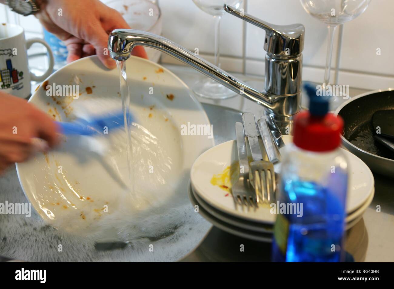 DEU, Deutschland: Reinigung von Geschirr mit der Hand in eine eigene Küche. Stockfoto