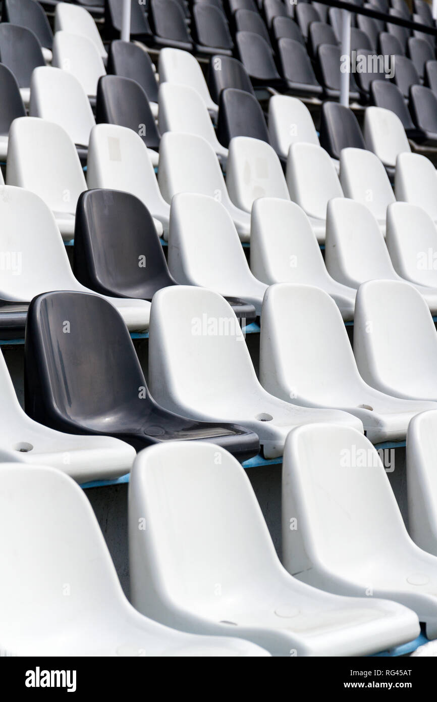Leere schwarze und weiße Stadion Sitze in den Reihen gemischt, diversity Konzept Stockfoto