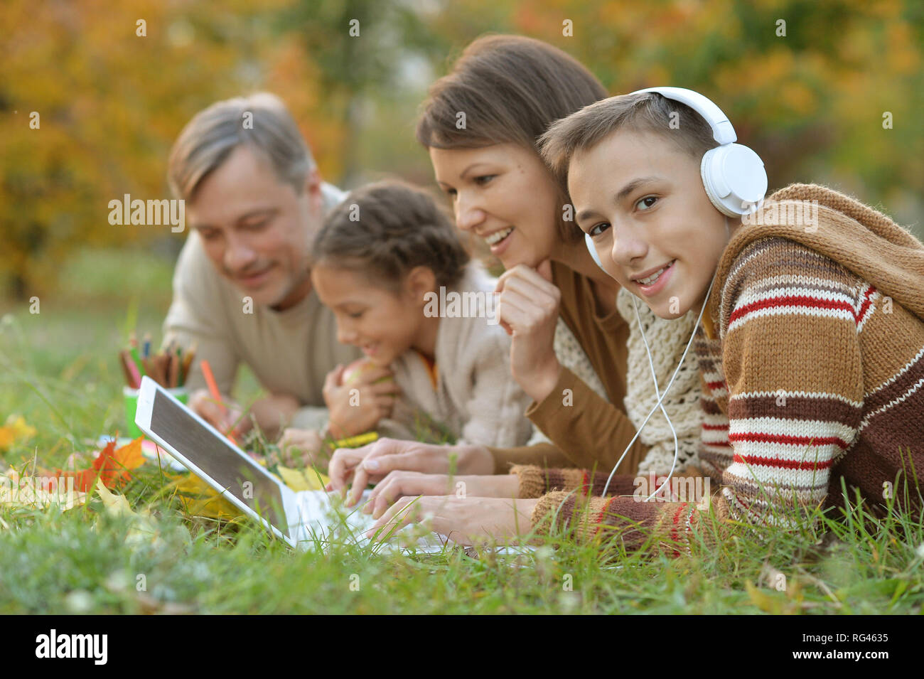 Portrait von Vater, Mutter und Kinder Hausaufgaben in Park Stockfoto