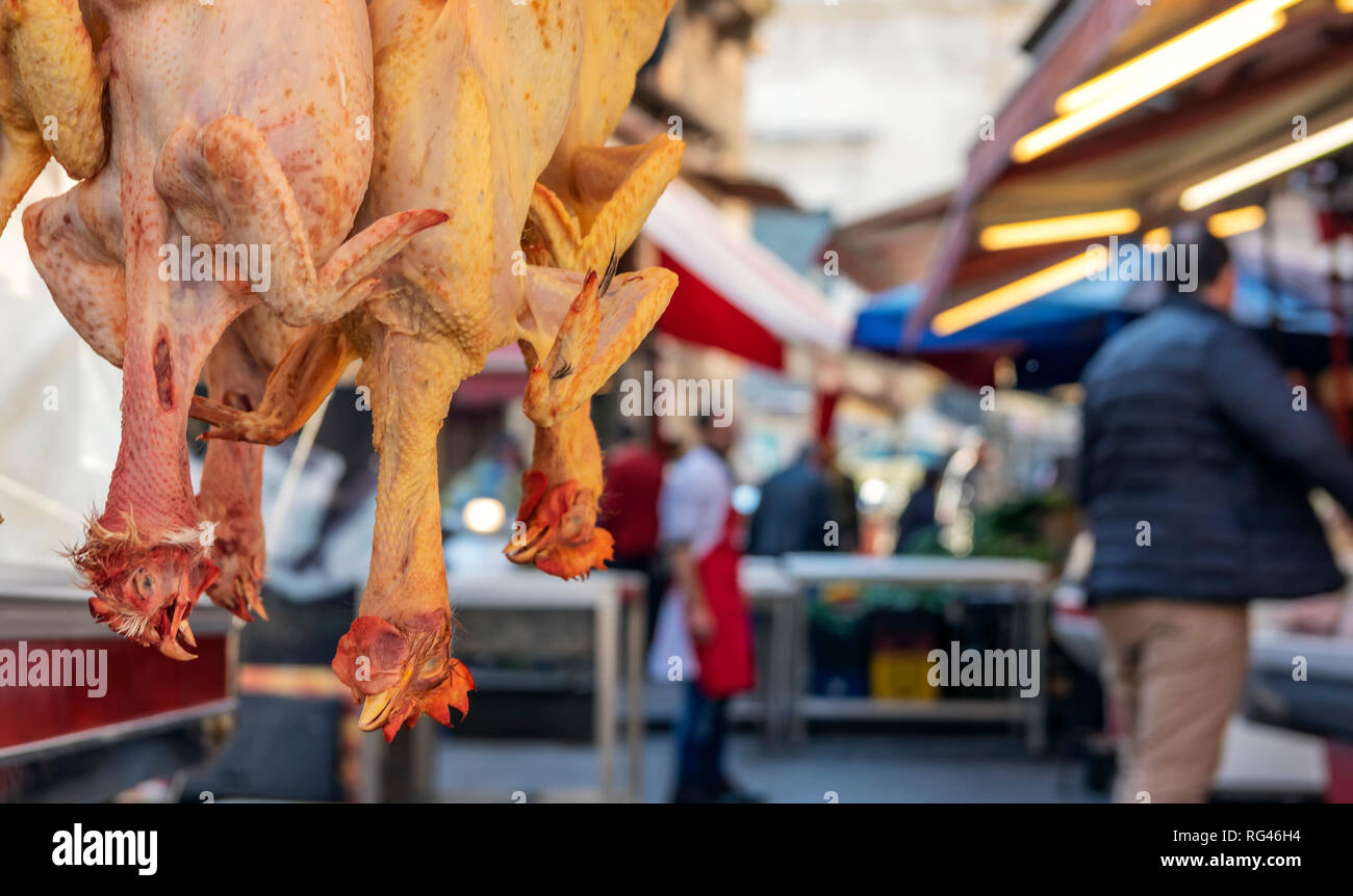 Gerupfte Hühner auf den Kopf hängen. Im Hintergrund unscharf Lebensmittelmarkt Stockfoto