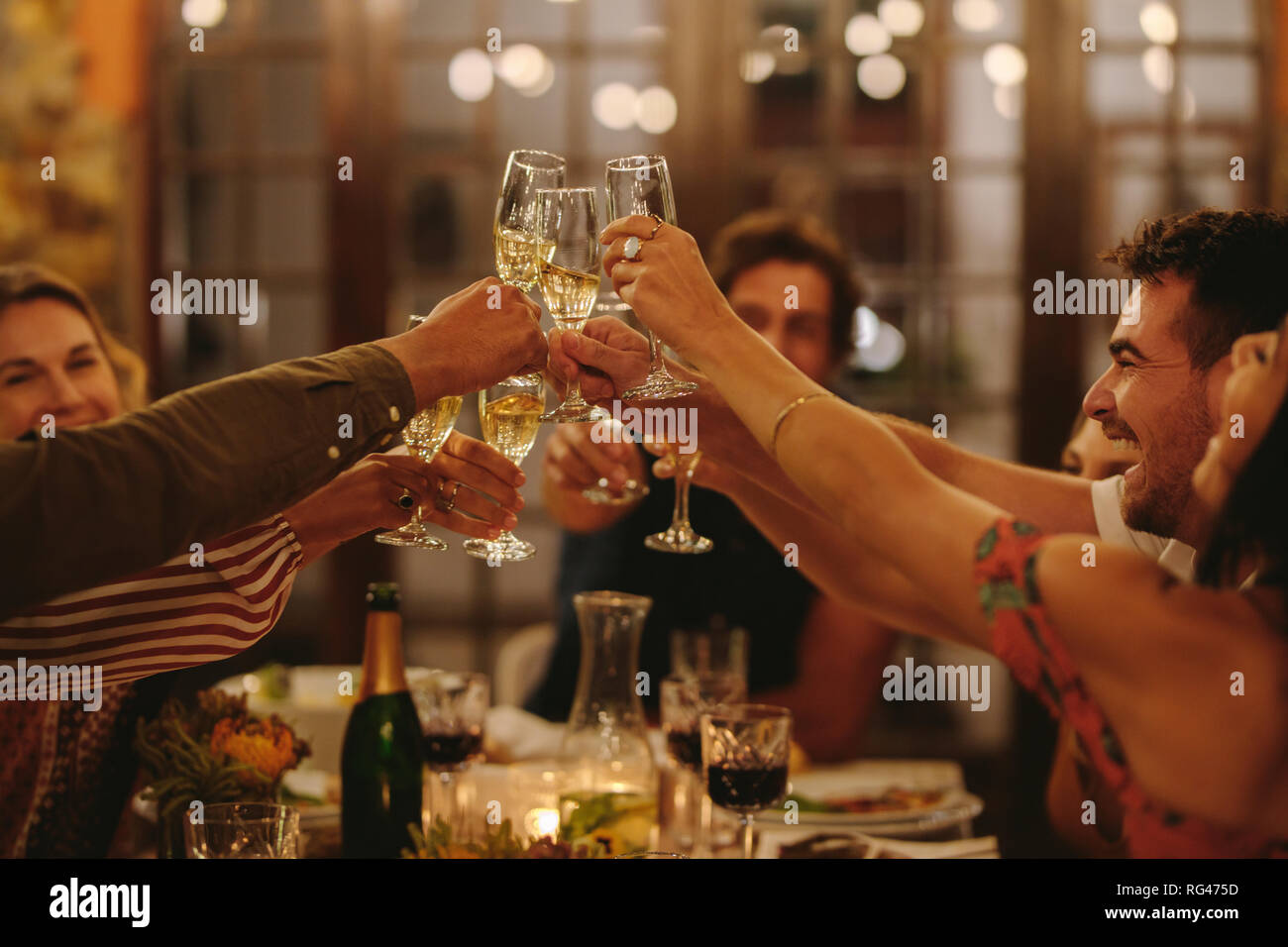 Gruppe von Menschen toasten Getränke an einer Partei. Junge Freunde Drinks einen besonderen Anlass zu feiern. Stockfoto