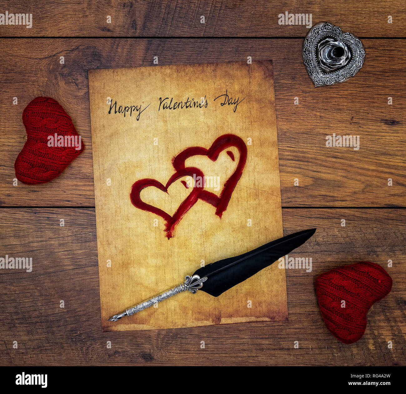 Classic Happy Valentinstag Karte Hand auf Pergament 2 rote kuscheln Herzen 2 rot lackiert reich verzierten, silbernen Feder geschrieben und auf Vintage oak Ansicht von oben stehen Stockfoto