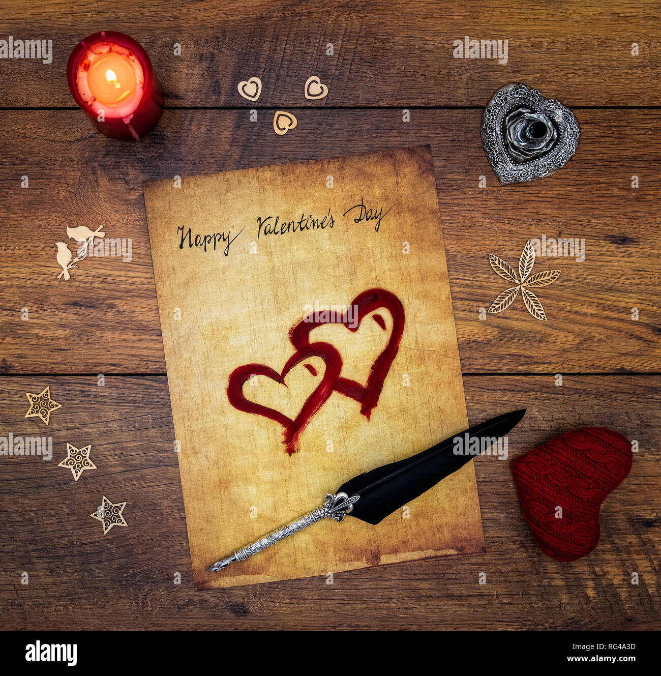 Classic Happy Valentinstag Karte Hand auf Pergament rot bemalten Herzen rote Kerze Dekorationen silber Feder geschrieben und auf Vintage oak Ansicht von oben stehen Stockfoto