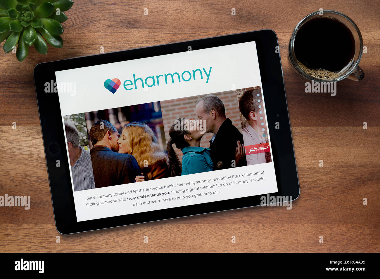 Die Website von eharmony ist auf einem iPad Tablet gesehen, auf einer hölzernen Tisch zusammen mit einem Espresso und einem Haus Anlage (nur redaktionelle Nutzung). Stockfoto