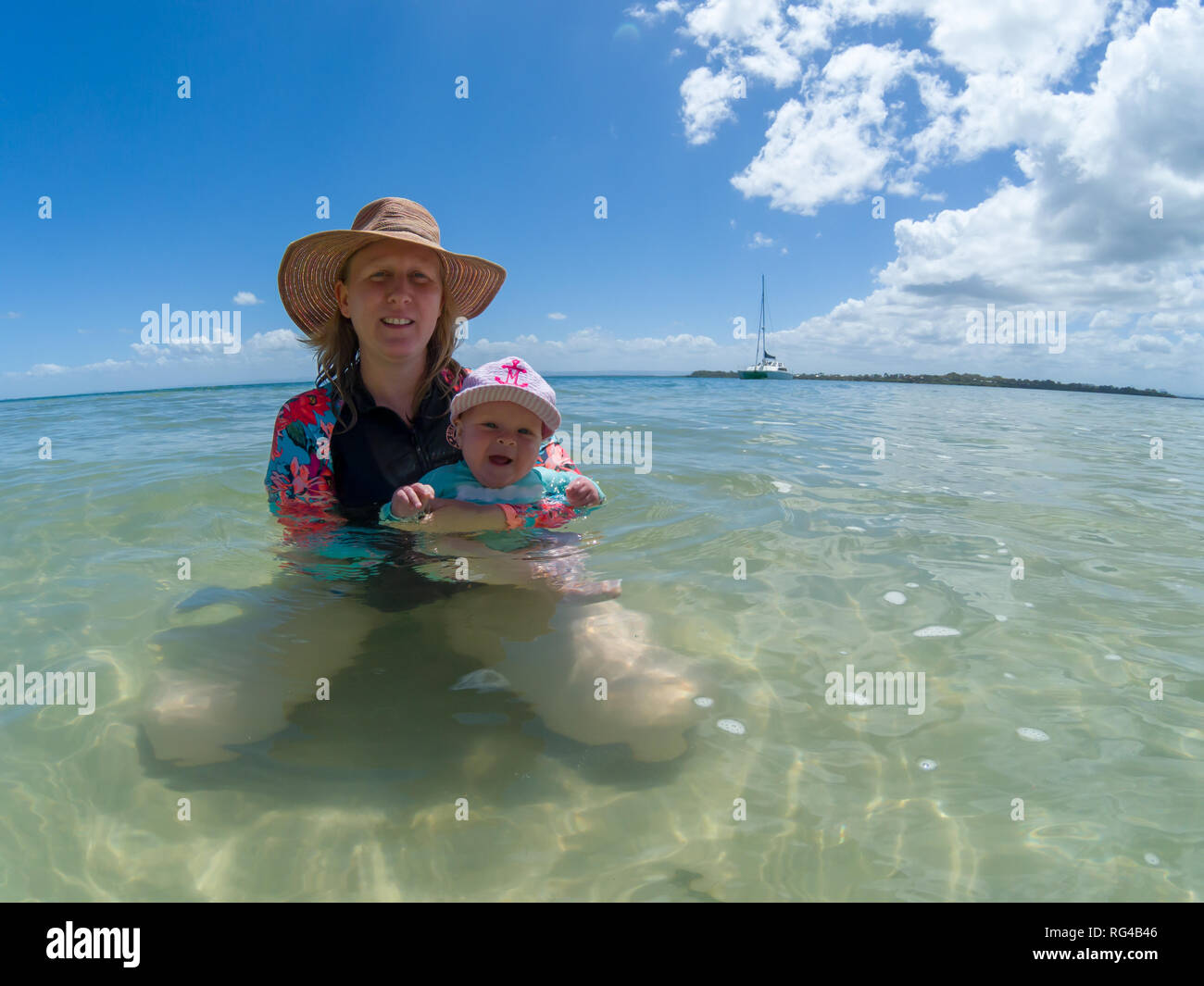 Eine blonde Mutter in ihrem späten dreissiger Jahre mit Baby spielen am Strand. Stockfoto