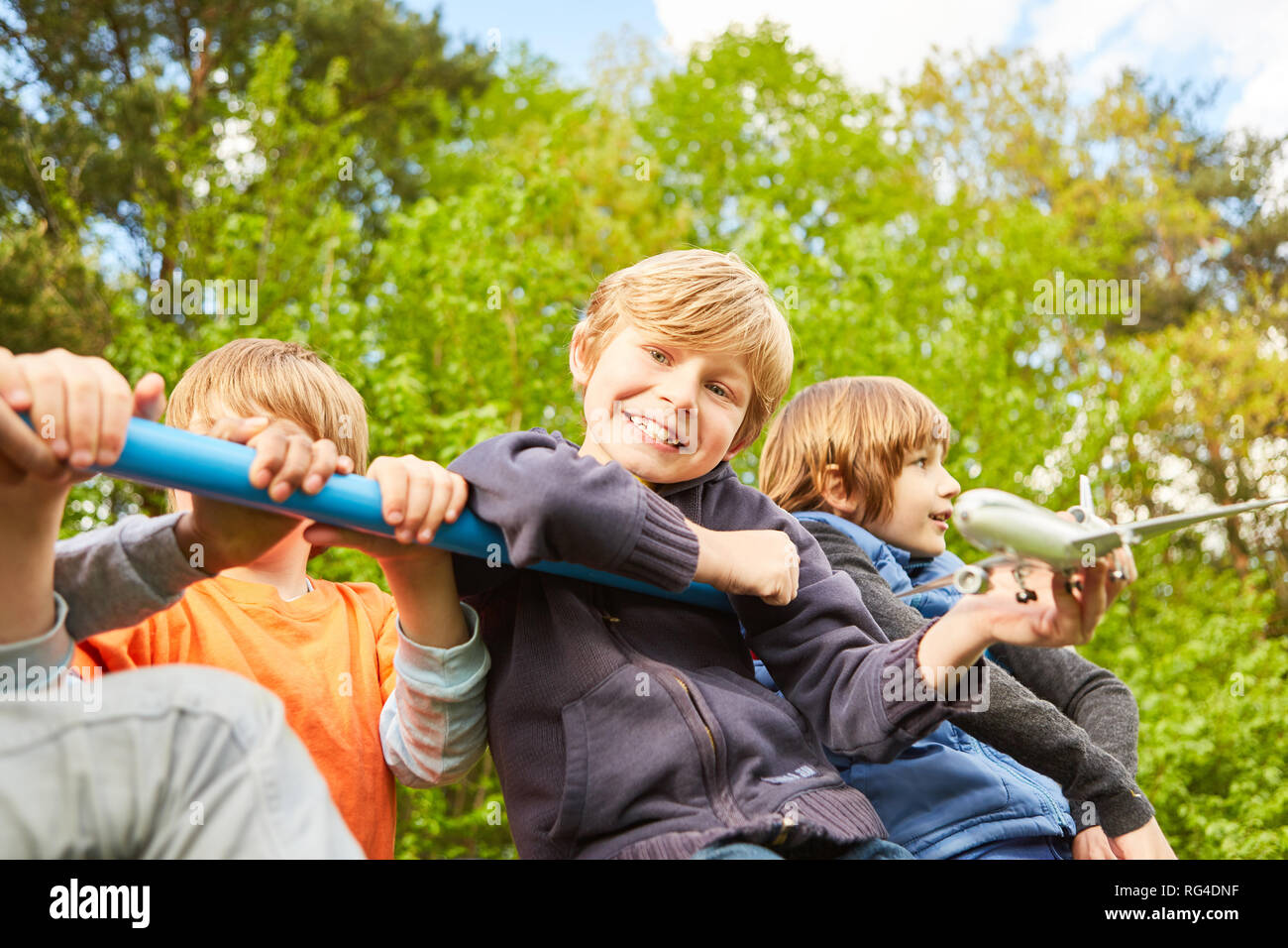 Fröhliche Gruppe von Kindern spielen auf einem Klettergerüst im Kindergarten im Sommer Stockfoto