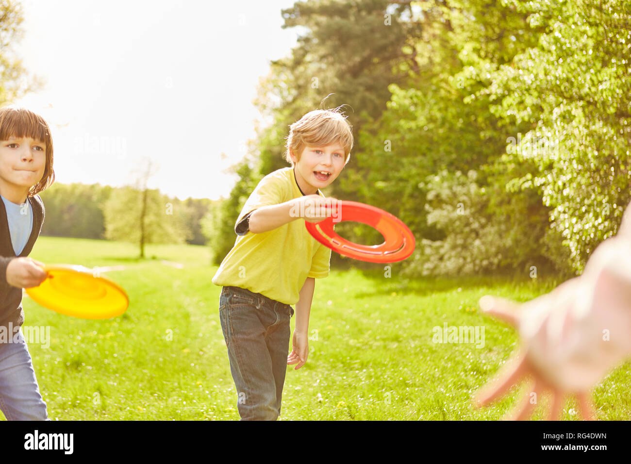 Aktive Kinder im Kindergarten haben sie Spaß, Frisbee Spiel im Park im Sommer Stockfoto
