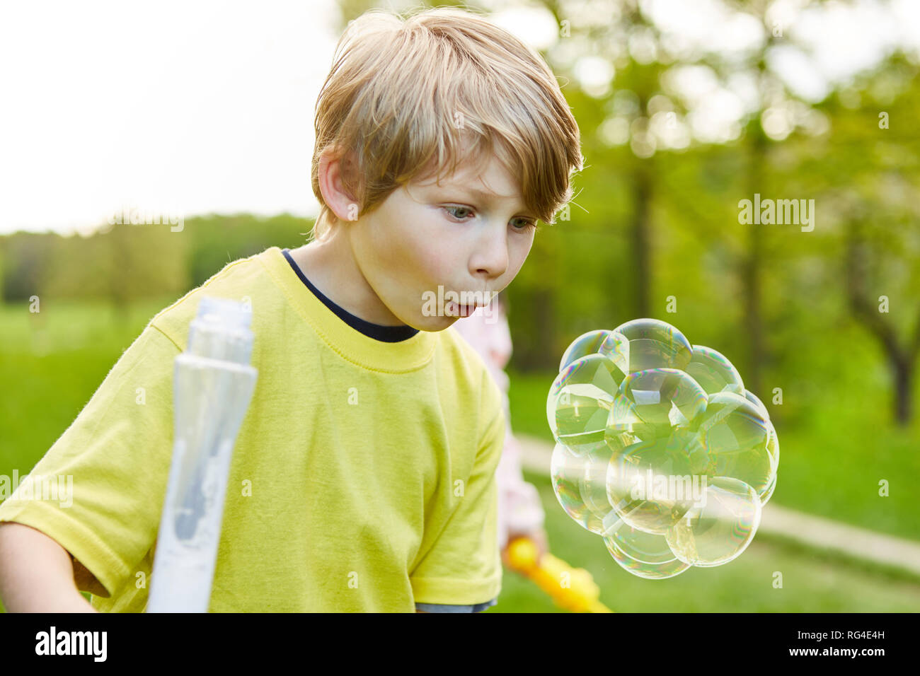 Junge in den Park ist durch eine große Seifenblase erstaunt Stockfoto