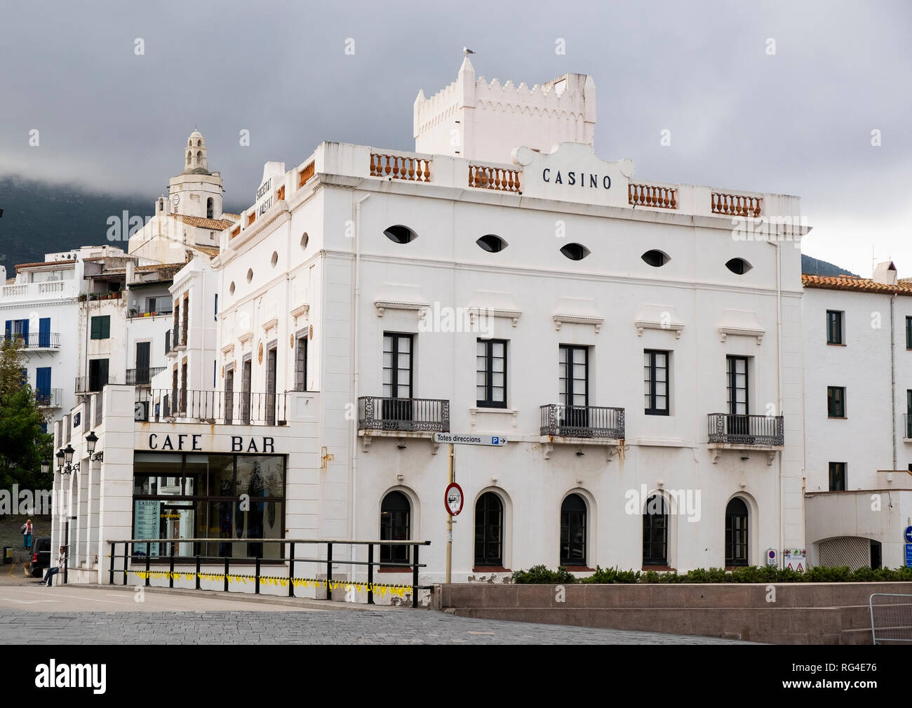 Bar Casino direkt am Meer, in der katalanischen Stadt Cadaqués mit dem Kirchturm im Hintergrund Stockfoto