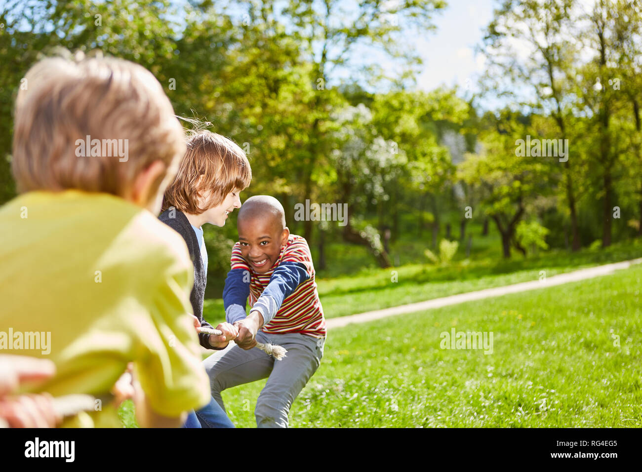 Kinder im Park auf einer Wiese am Wettbewerb in Tauziehen beim Kindergeburtstag Stockfoto