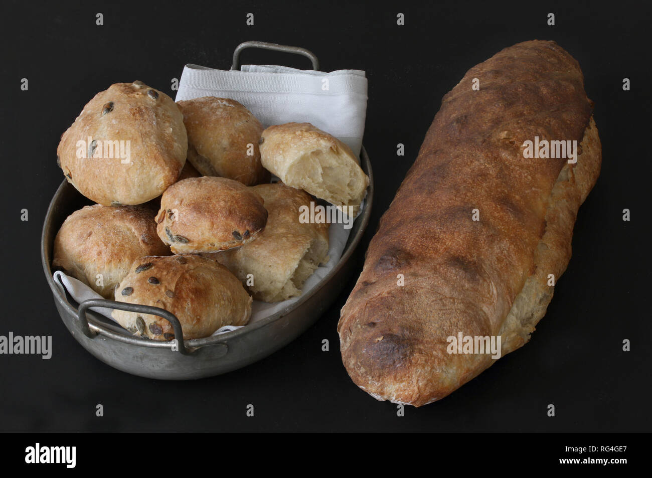 Nur mit Sauerteig gebacken, hausgemachtes Brot und Brötchen mit Samen - Rustic. Brötchen im alten antiken Metallkorb liegen mit Serviette. Schönen malerischen im Stockfoto