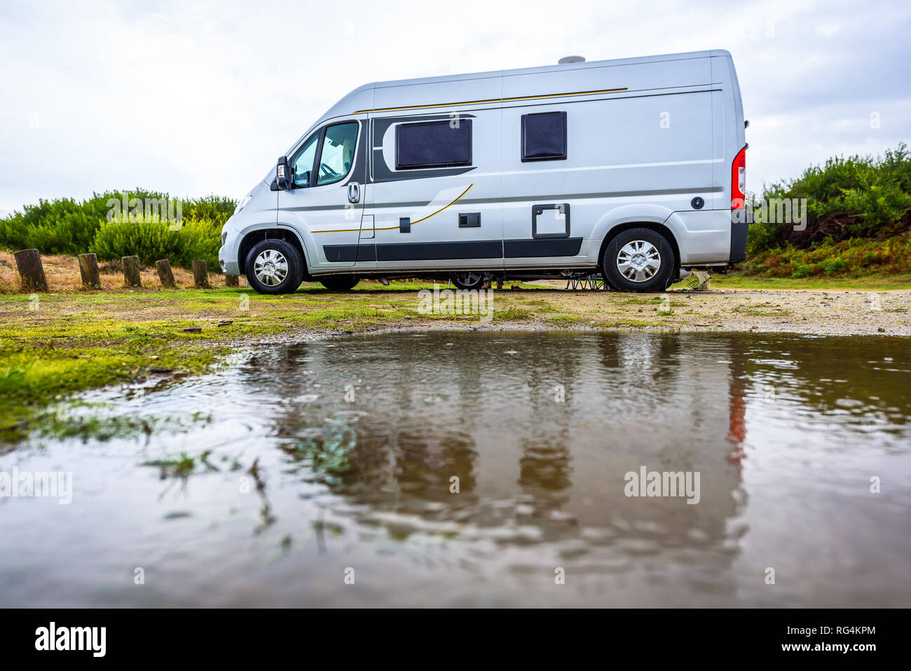 Wohnmobil oder Reisemobil Campingplatz an regnerischen Tag mit Regen Pfützen. Familienurlaub Straße Reise mit Wohnmobil, Wohnmobil oder RV mit schlechtem Wetter. Holida Stockfoto